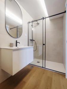 ein Badezimmer mit Dusche, Waschbecken und Spiegel in der Unterkunft Casa Náutica T1 Norte in Ovar