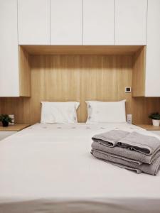 ein Bett mit weißer Bettwäsche und weißen Kissen in der Unterkunft Casa Náutica T1 Norte in Ovar