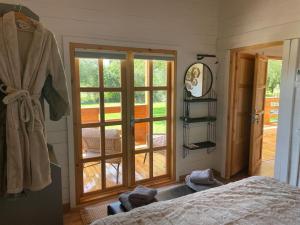 a bedroom with a bed and a sliding glass door at The Retreat - Oak Lodge in Corfu
