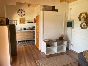 a room with a kitchen with a table and a clock at The Retreat - Oak Lodge in Corfu