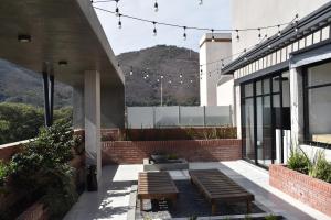 un patio avec des bancs et un bâtiment avec des montagnes en arrière-plan dans l'établissement Departamento - Salta Capital sm - Edificio Usina, à Salta