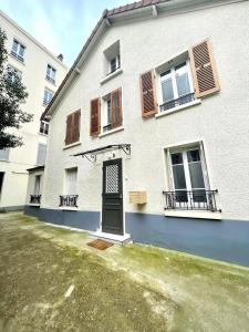 a white building with a door and windows at Nice area 5 minutes from Paris in Suresnes