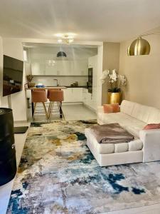 a living room with a white couch and a kitchen at Nice area 5 minutes from Paris in Suresnes