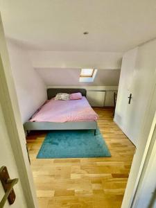 a small bedroom with a bed and a rug at Nice area 5 minutes from Paris in Suresnes