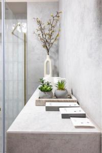 a bathroom counter with two potted plants on it at Comfy Aparts Plac Solny II in Głogów