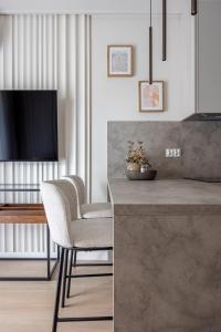 a kitchen with two chairs and a table with a television at Comfy Aparts Plac Solny II in Głogów