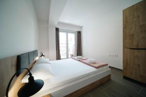 a bedroom with a large white bed and a window at Eyebee apartments in Ohrid