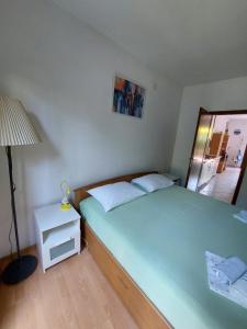 a bedroom with a bed and a lamp and a mirror at Apartment Marinetto in Stari Grad