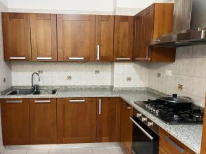 a kitchen with wooden cabinets and a sink and a stove at Venice Home Free Parking in Mestre