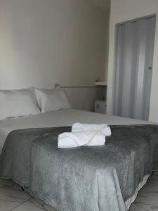 a bedroom with a bed with towels on it at Pousada Velho Brito in Piranhas