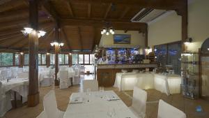 a restaurant with white tables and chairs and a waitress at Hotel Le Tre Caravelle in Palinuro
