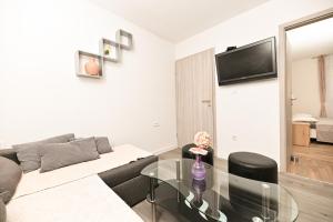 a living room with a couch and a glass table at New, close to the beach apartment with terrace, grill, parking, 2-rooms in Trogir