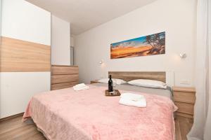 a bedroom with a bed with two towels on it at New, close to the beach apartment with terrace, grill, parking, 2-rooms in Trogir