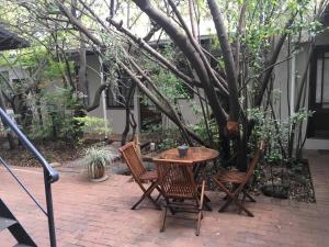 a table and chairs on a patio under a tree at Melville Turret Guesthouse in Johannesburg