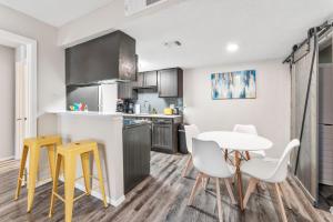 a kitchen with a table and yellow stools in a room at SoCo Chic Apartment Suites Close to Downtown in Austin