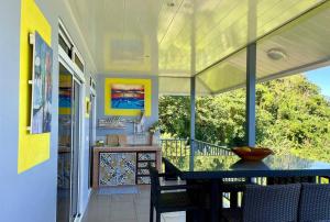 a screened in porch with a table and chairs at Villa Maui1 in Vaihi