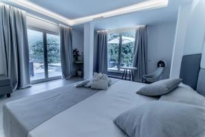 duże białe łóżko w pokoju z oknami w obiekcie Hotel Lago Bin w mieście Rocchetta Nervina +37 zdjęć