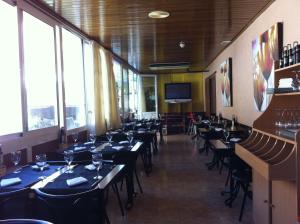 un comedor lleno de mesas y sillas con ventanas en Hotel Rodsan Suizo, en Castelldefels 20 fotos más