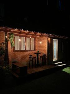 a patio at night with a table and chairs at Casinha do Fotógrafo em Domingos Martins a 7km do Centro in Domingos Martins
