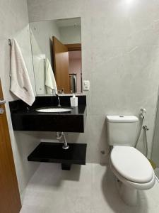 a bathroom with a toilet and a sink and a mirror at Suíte completa em Gramado in Gramado