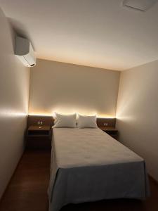 a small room with a bed with two pillows at Suíte completa em Gramado in Gramado