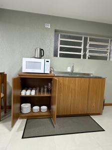 a kitchen with a sink and a microwave at Suíte completa em Gramado in Gramado +7 photos