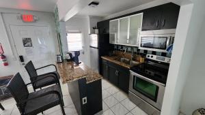 a kitchen with black cabinets and a counter top at Bayfront Apartment Breathtaking Views- one bedroom w balcony- living room -Free Parking in Miami Beach