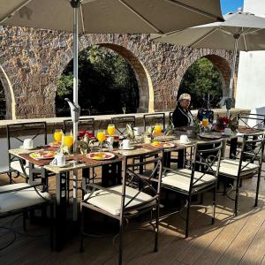 a table with chairs and an umbrella on a deck at Hotel Boutique Casa San Diego in Morelia