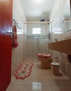 a bathroom with a toilet and a red door at Pousada Charme da Serra in Bom Jardim da Serra