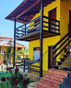 a yellow house with a staircase in front of it at Pousada Matuto Cipó in Serra do Cipo