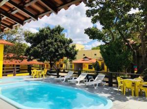 a large swimming pool with chairs and a table at Pousada Matuto Cipó in Serra do Cipo