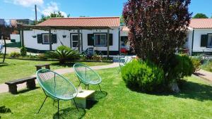 two chairs sitting in the grass near a house at Quinta dos Sentidos Eco Nature Retreat in Azores in São Vicente Ferreira