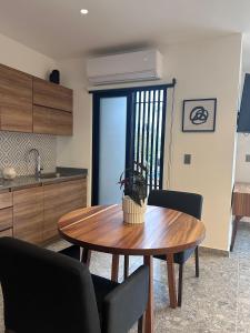 a kitchen with a wooden table with chairs and a dining room at Mako 235 in Tepic