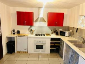 a kitchen with red cabinets and a stove top oven at la kasaloc in Saint-Laurent du Maroni