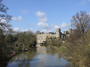 a large castle with a river in front of it at The Cottage in Stratford-upon-Avon