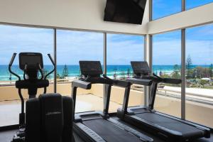 un gimnasio con tres máquinas cardiovasculares frente a una ventana en Paradise Centre Apartments managed by Gchs, en Gold Coast