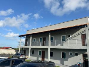 a white building with cars parked in front of it at Sal-beach in Salinópolis