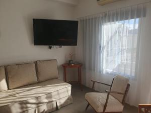 a living room with a couch and a window at Heart Depto 1 Viedma Centro Confortable y Optima Ubicación in Viedma