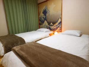 富士吉田市富士山結アパートメント的墙上画画的房间的三张床