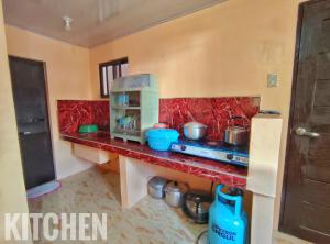 a kitchen with a counter with a stove top oven at Patar White Beach Bolinao- LILYBETH TRANSIENT HOUSE 1 # -NOT Beachfront in Bolinao
