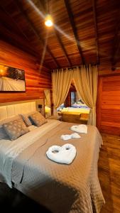 a bedroom with two beds with towels on them at Cabana Alpen Ville Rural com Banheira in Bom Jardim da Serra