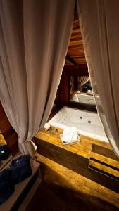 a view of a room with a bed and a curtain at Cabana Alpen Ville Rural com Banheira in Bom Jardim da Serra +48 photos