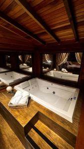 a large bath tub sitting on a wooden floor at Cabana Alpen Ville com Banheira - Rural in Bom Jardim da Serra