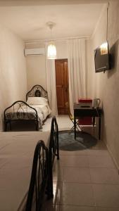 une chambre avec un lit, une table et une télévision dans l'établissement Palazzo montagna, à Grotte