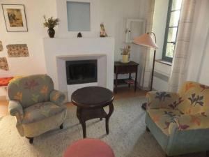 un soggiorno con due sedie e un camino di Lo Cantou Comfortable holiday residence a Camplong-dʼAude
