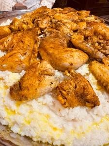 a plate of food with chicken and rice at Dreams beach hostel in Dubai