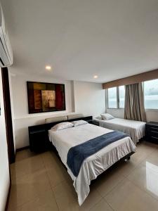 ein Hotelzimmer mit zwei Betten und einem Fenster in der Unterkunft Paraíso en Bocagrande con Vista al Mar in Cartagena de Indias