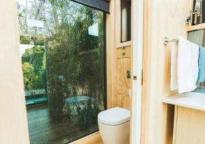 a bathroom with a toilet and a large window at Mākoha PurePod in Kerikeri