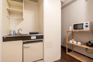 a small kitchen with a sink and a microwave at ELM Takadanobaba in Tokyo