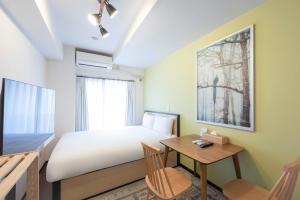 a small bedroom with a bed and a table at ELM Takadanobaba in Tokyo